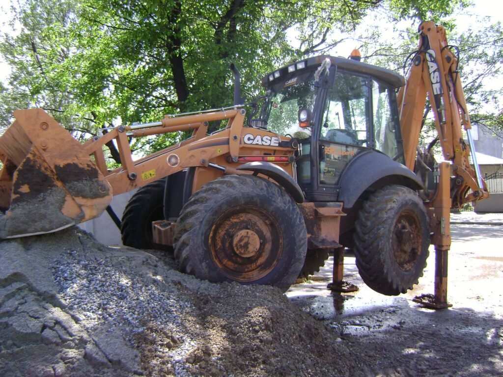 Retroexcavadora CASE con apoyos extendidos en obra