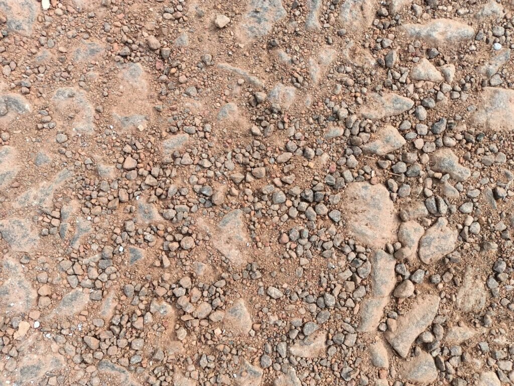 Acercamiento a una base de grava compactada con piedra de distintos tamaños
