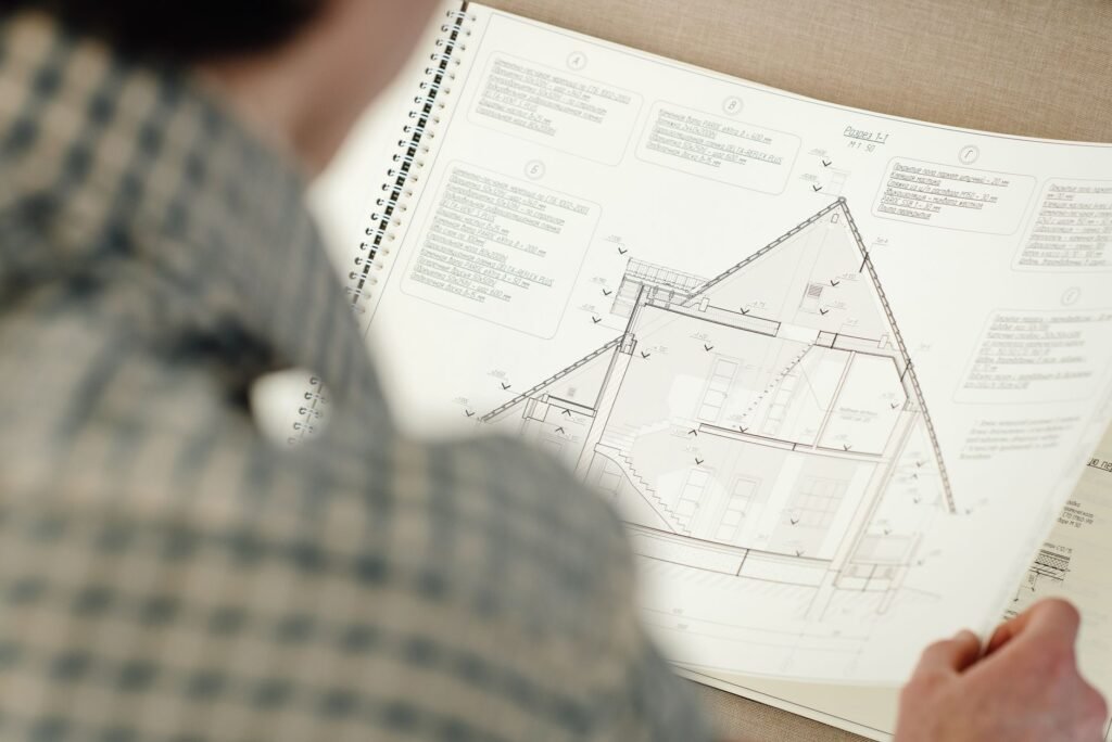 Persona revisando un plano arquitectonico para cuantificar volumenes de obra