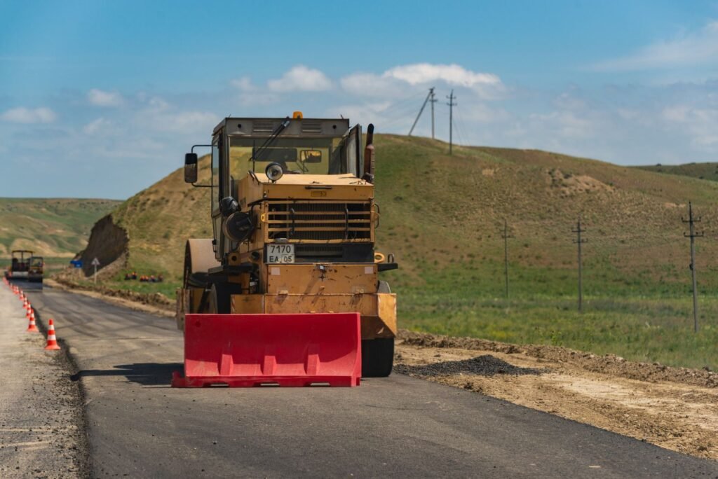 Vibrocompactador dando pasadas sobre la capa de un camino en zona rural