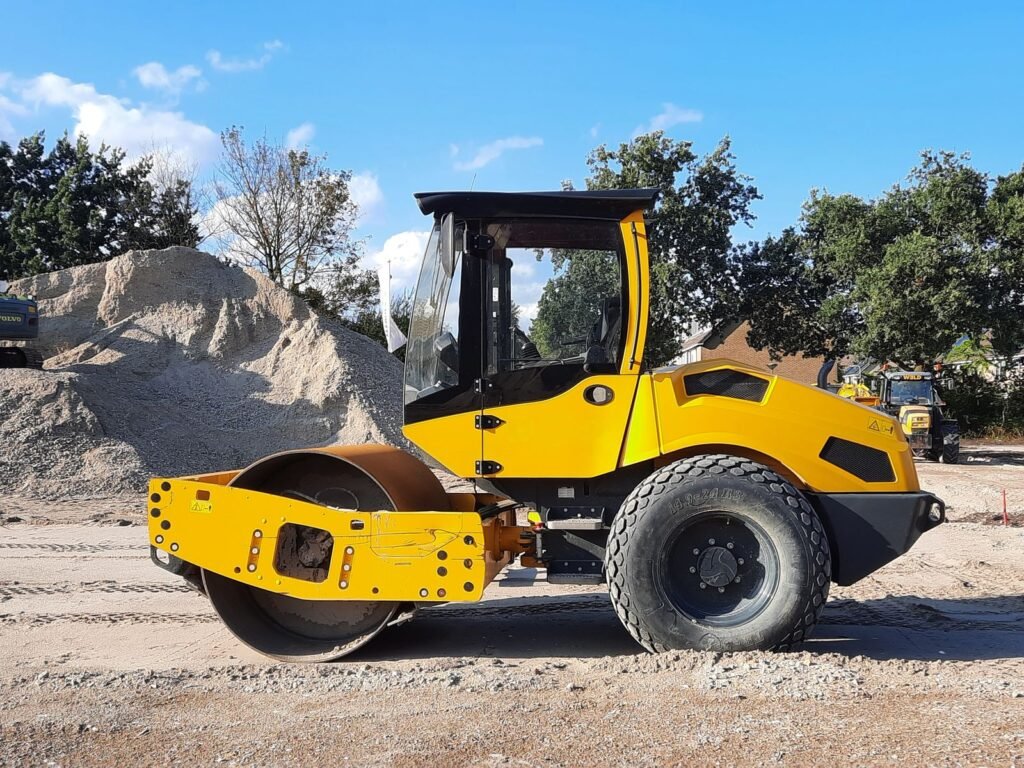 Vibrocompactador de rodillo liso compactando una base de grava en obra