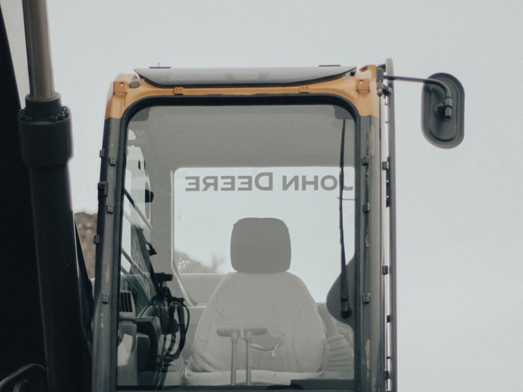Cabina de operador de una excavadora vista de frente con el asiento y los mandos