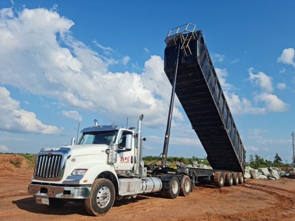 Tractocamión con góndola de volteo levantada descargando material