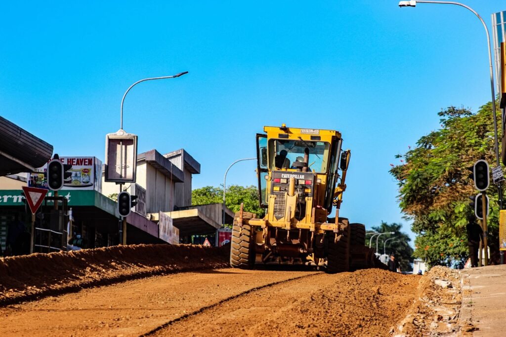 Motoconformadora perfilando una calle de terracería en zona urbana