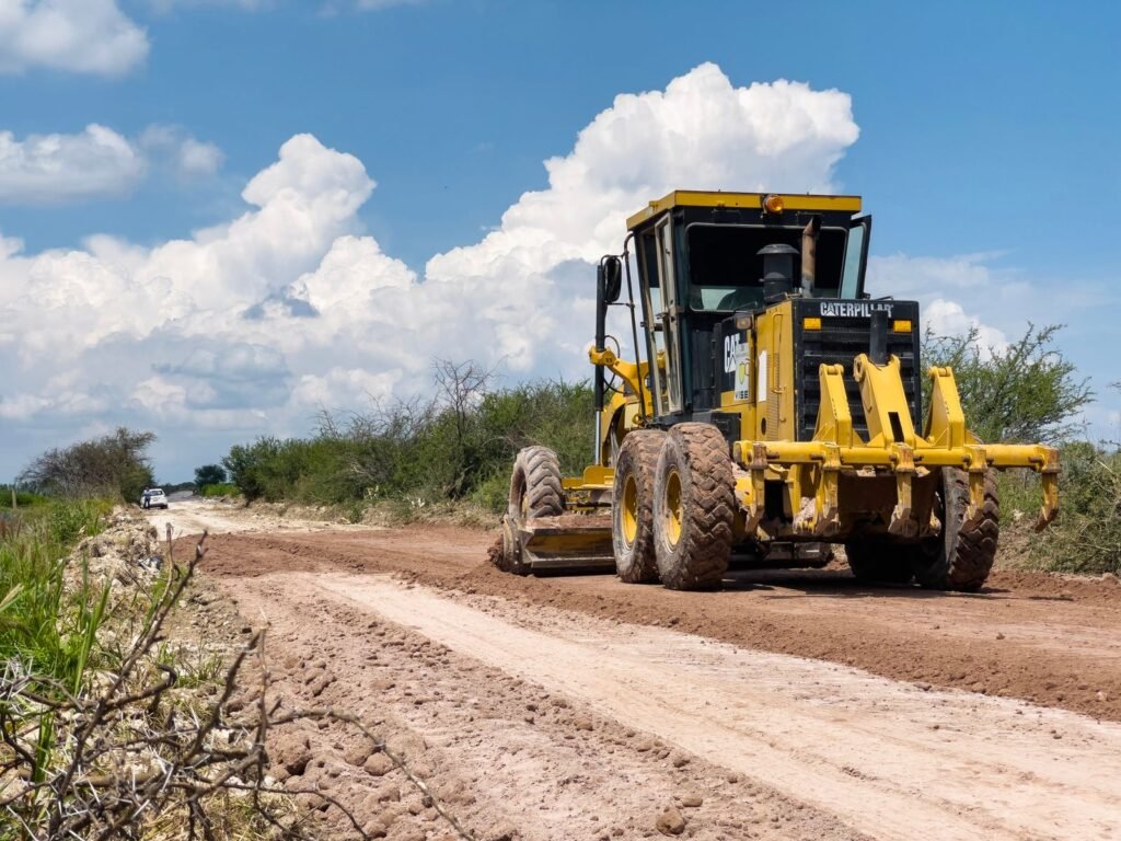 Motoconformadora nivelando un camino de terracería con la hoja en ángulo