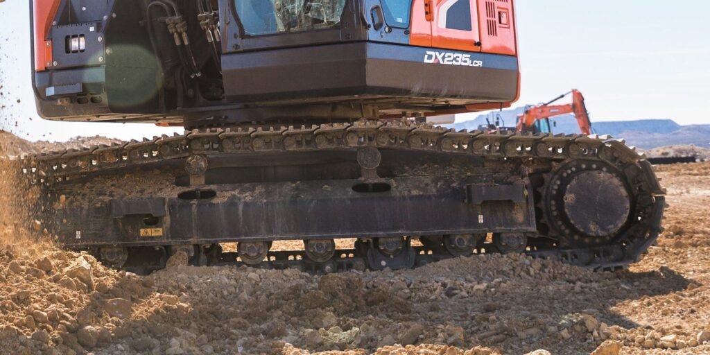 Tren de rodaje de una excavadora con zapatas, rodillos y rueda motriz dentada